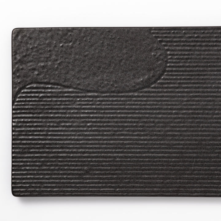 Textured black ceramic dinner plate with ridged woodgrain and matte-gloss accents, ideal for refined Japanese dining and modern presentation.