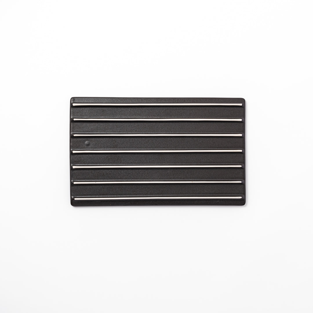 Textured black ceramic dinner plate with ridged woodgrain and matte-gloss accents, ideal for refined Japanese dining and modern presentation.