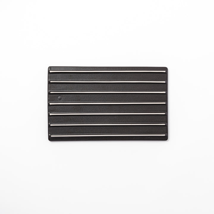 Textured black ceramic dinner plate with ridged woodgrain and matte-gloss accents, ideal for refined Japanese dining and modern presentation.
