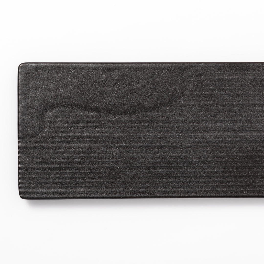 Rectangular black ceramic serving plate with a subtle ridged woodgrain texture, perfect for stylish Japanese meals and contemporary plating.