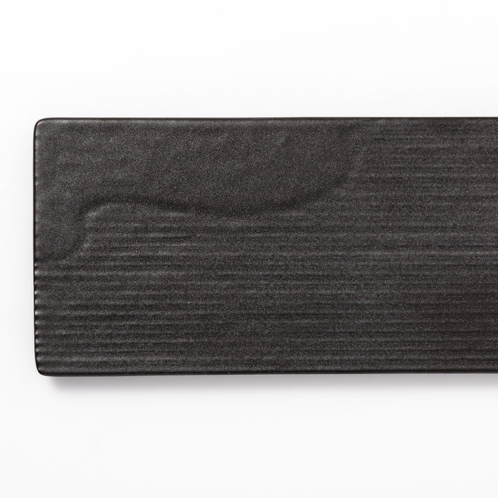 Rectangular black ceramic serving plate with a subtle ridged woodgrain texture, perfect for stylish Japanese meals and contemporary plating.