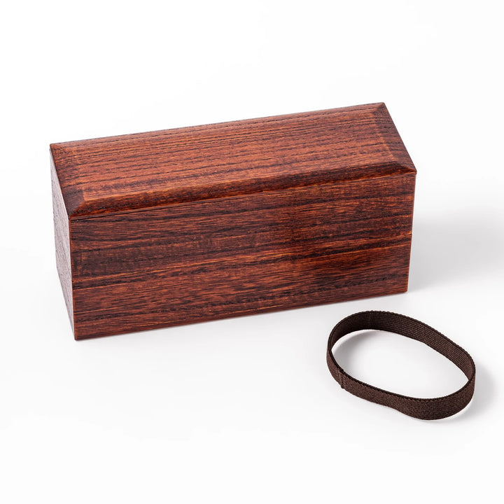 Dark brown two-tier bento box made from richly grained paulownia wood, secured with a black elastic band, ideal for stylish Japanese lunches.