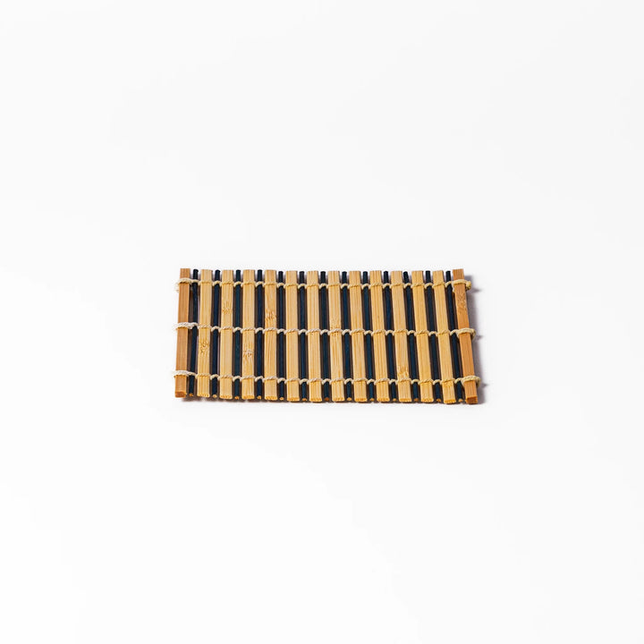 Two-tone bamboo coaster with alternating dark and natural bamboo slats, hand-tied with twine—perfect for protecting surfaces with Japanese flair.