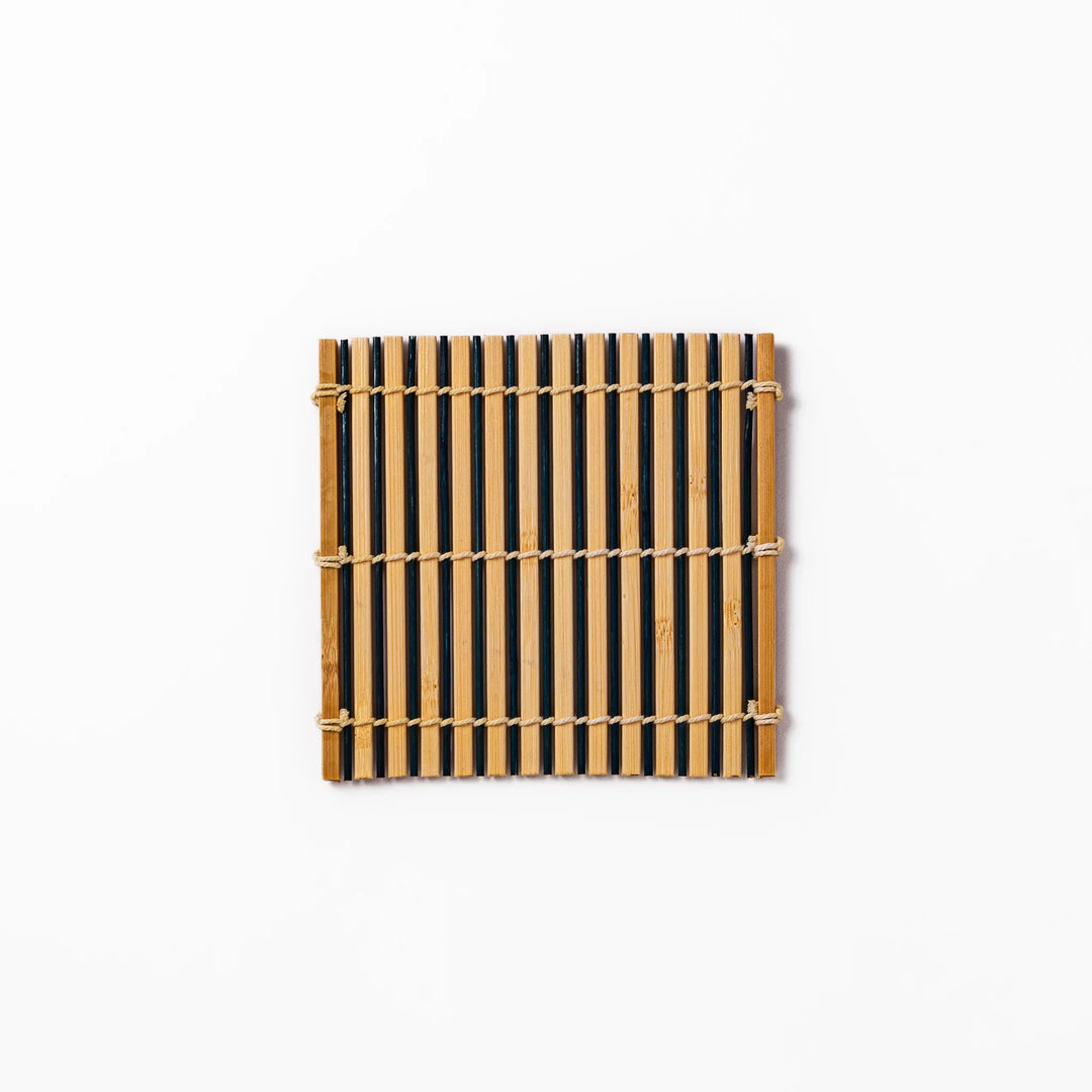 Two-tone bamboo coaster with alternating dark and natural bamboo slats, hand-tied with twine—perfect for protecting surfaces with Japanese flair.
