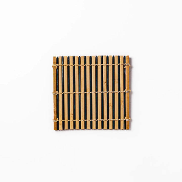 Two-tone bamboo coaster with alternating dark and natural bamboo slats, hand-tied with twine—perfect for protecting surfaces with Japanese flair.
