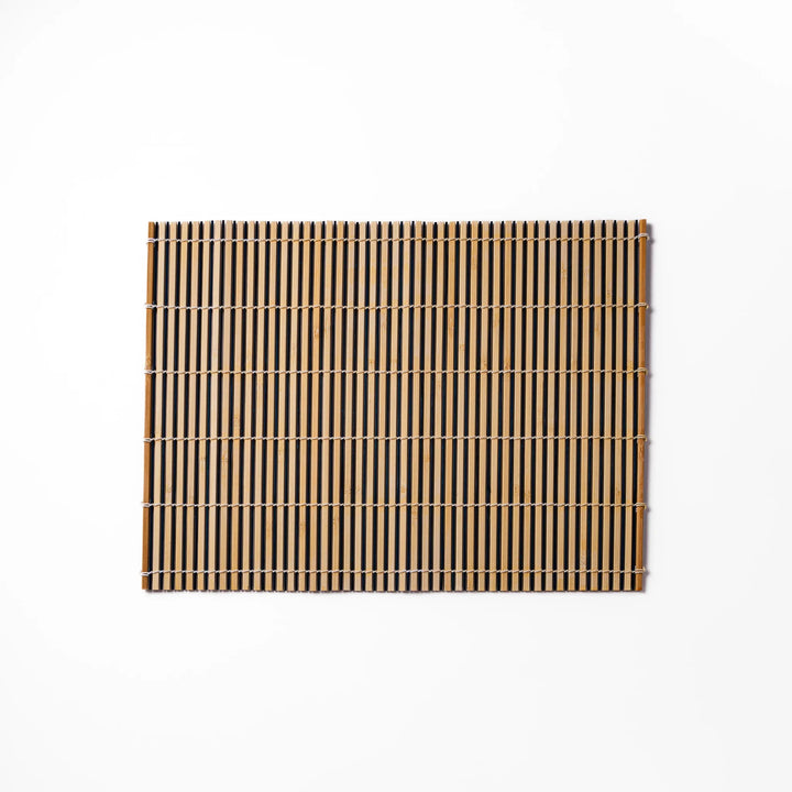 Two-tone bamboo table mat with alternating light and dark slats, tightly woven with white cord—ideal for adding texture to your Japanese table setting.