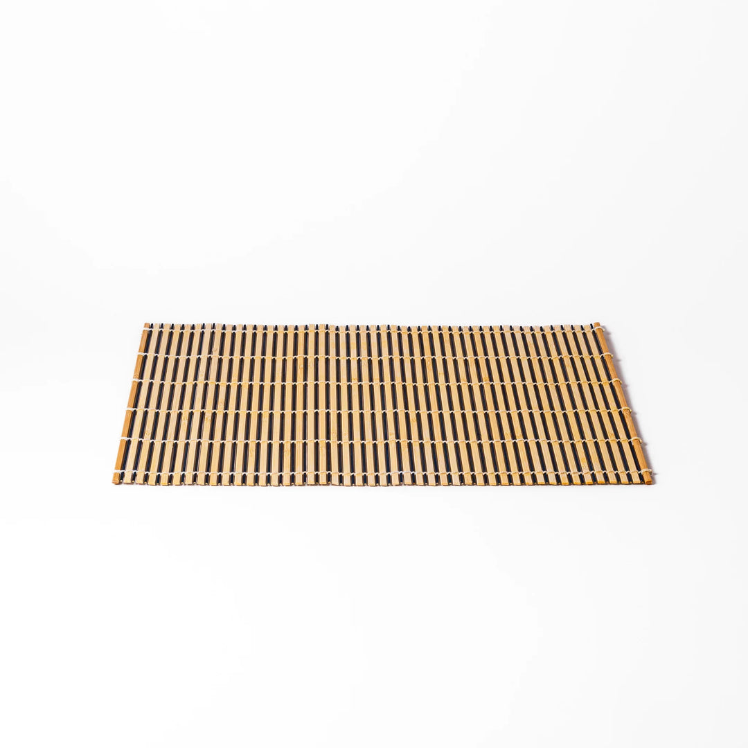 Two-tone bamboo table mat with alternating light and dark slats, tightly woven with white cord—ideal for adding texture to your Japanese table setting.