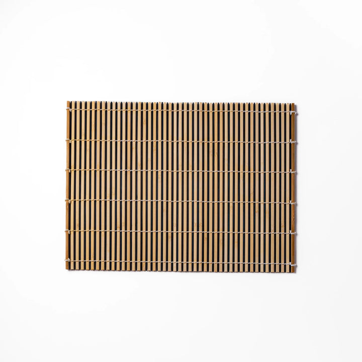 Two-tone bamboo table mat with alternating light and dark slats, tightly woven with white cord—ideal for adding texture to your Japanese table setting.