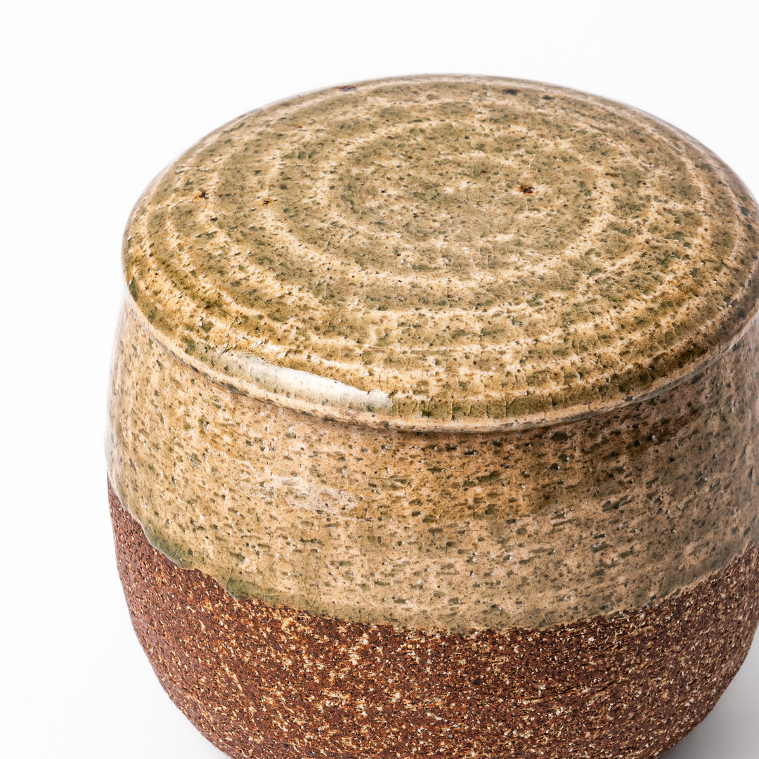 Two-tone Japanese ceramic rice storage bowl with lid, featuring smooth glazed top and textured brown lower half for rustic charm.