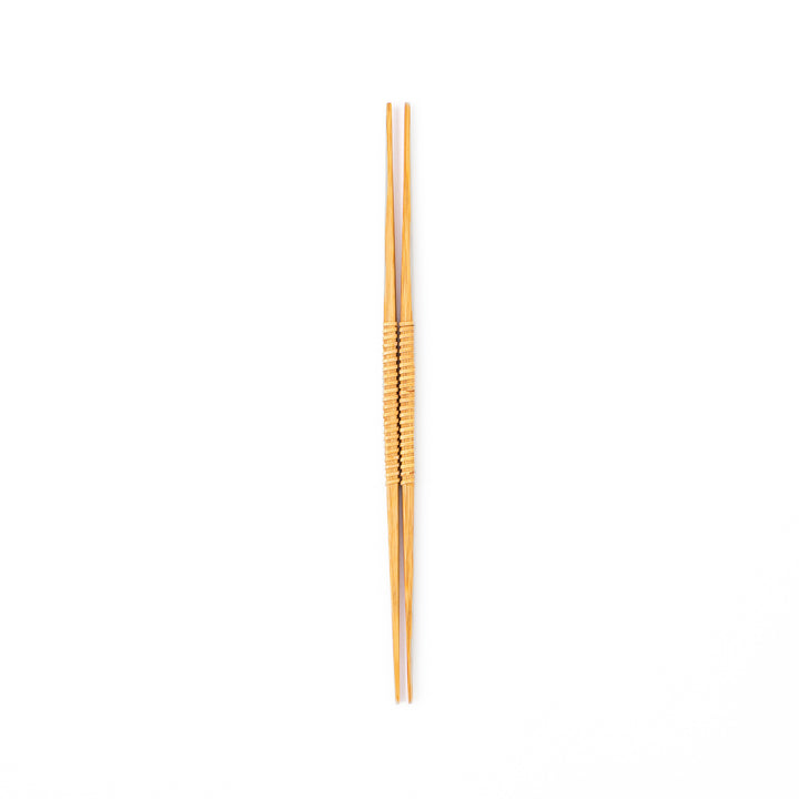 A pair of Japanese bamboo serving chopsticks featuring fine tapered tips on both ends and a textured wrapped center grip