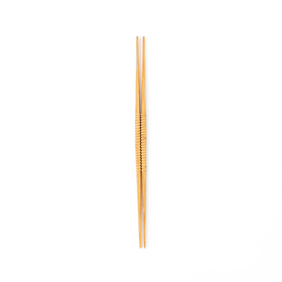 A pair of Japanese bamboo serving chopsticks featuring fine tapered tips on both ends and a textured wrapped center grip