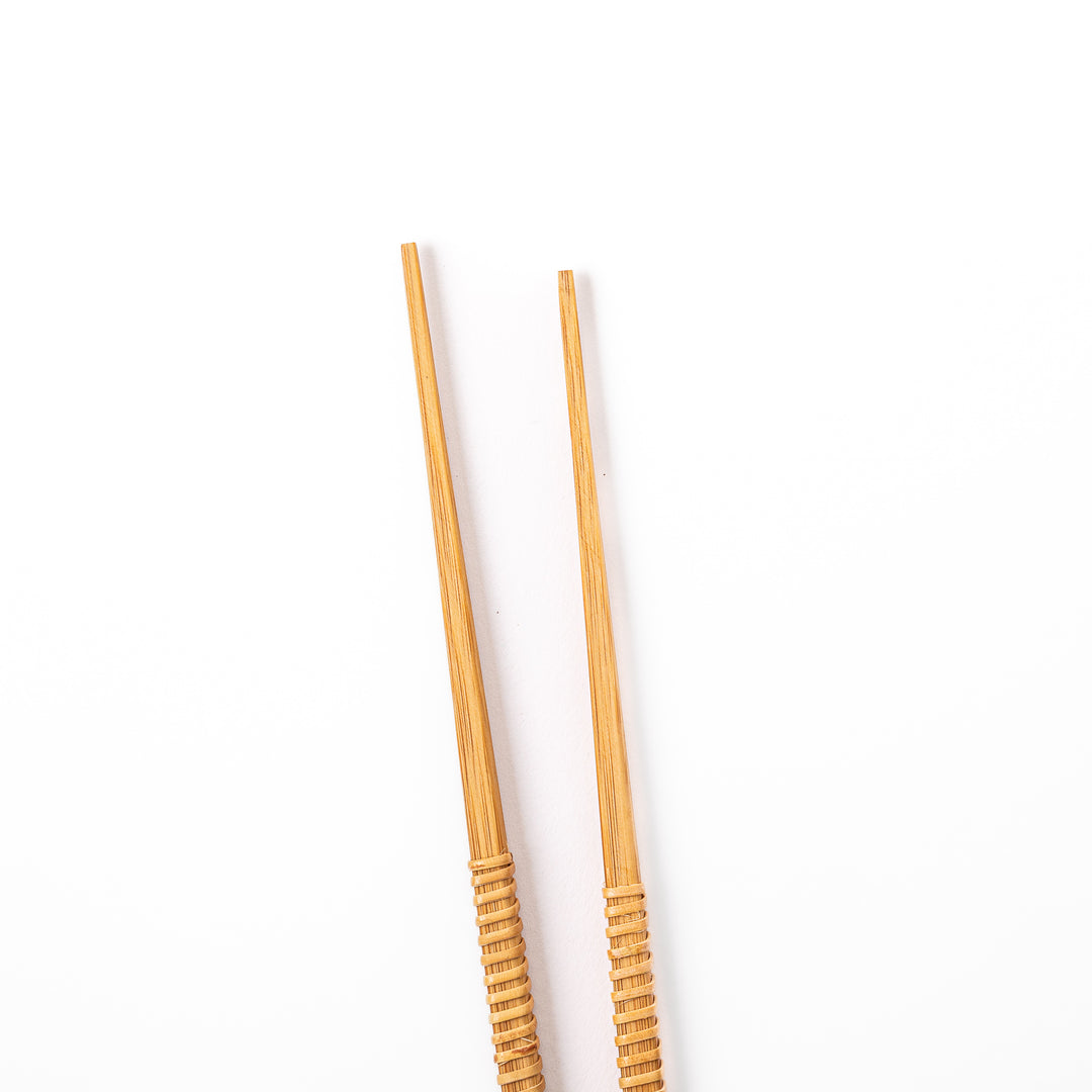 A pair of Japanese bamboo serving chopsticks featuring fine tapered tips on both ends and a textured wrapped center grip