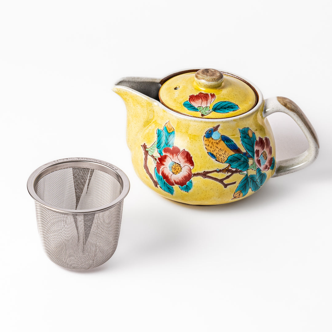 Ceramic teapot with a warm yellow glaze featuring hand-painted camellia flowers and a bird motif, paired with a removable stainless steel strainer.
