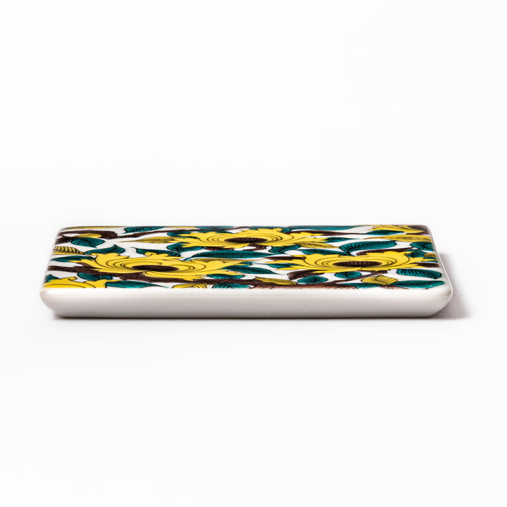 Square Japanese ceramic coaster adorned with vivid yellow peony blooms and teal leaves, adding elegance and charm to any dining table setting.