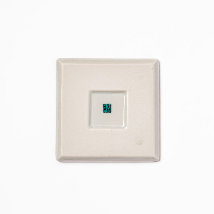 Square Japanese ceramic coaster adorned with vivid yellow peony blooms and teal leaves, adding elegance and charm to any dining table setting.