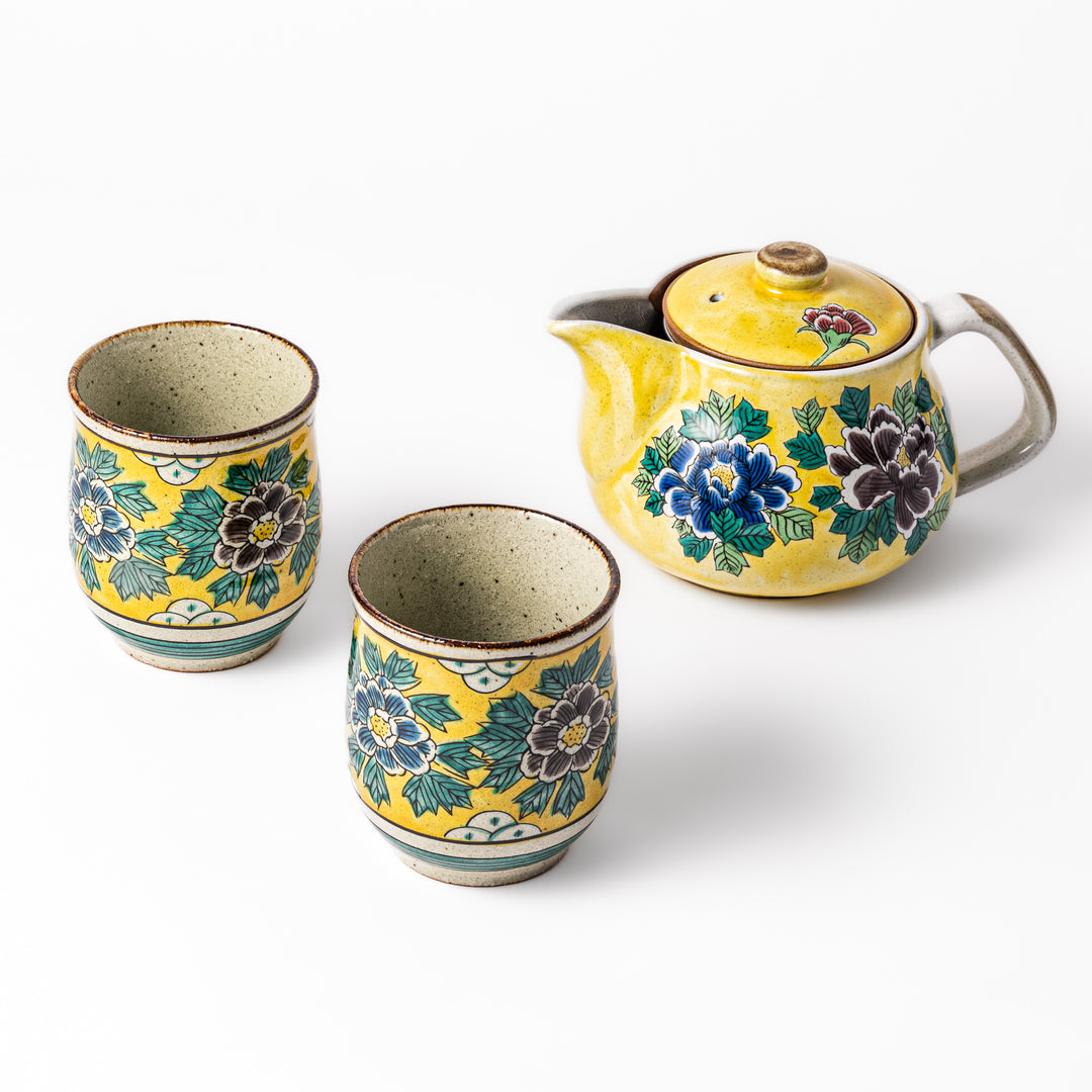 Three piece ceramic tea set with a yellow glaze featuring hand-painted peony flowers, including a teapot and two matching floral cups.