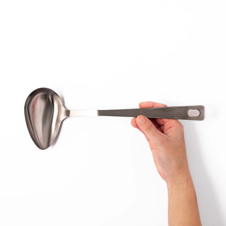 Japanese stainless steel soup ladle with long handle and deep curved bowl for serving soups and stews.