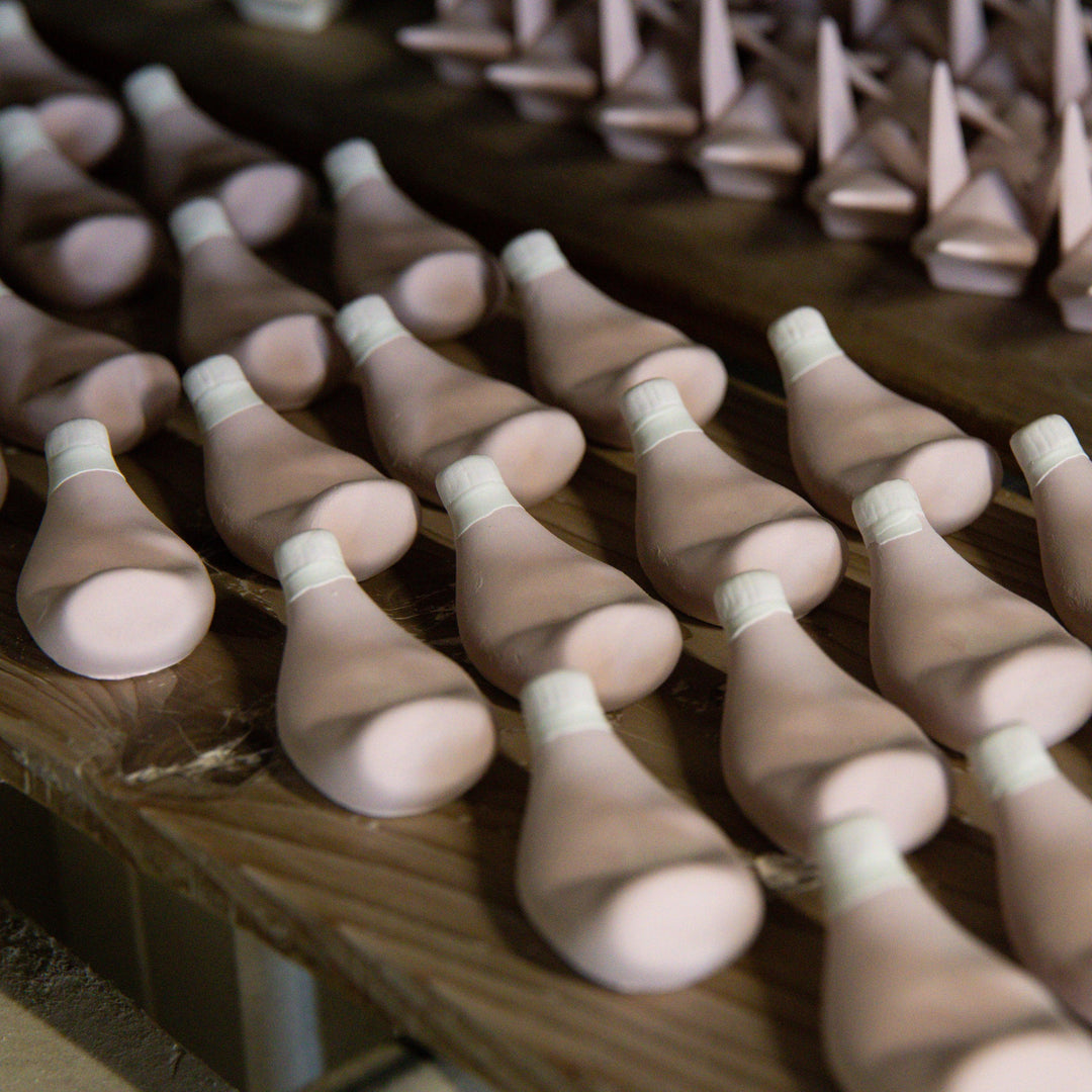 Rows of shaped clay pieces drying in the workshop as part of the artisan process of crafting ceramic accessories