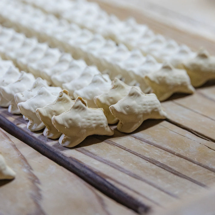 Rows of shaped ceramic pieces drying in the workshop as part of the artisan process of crafting small pottery items