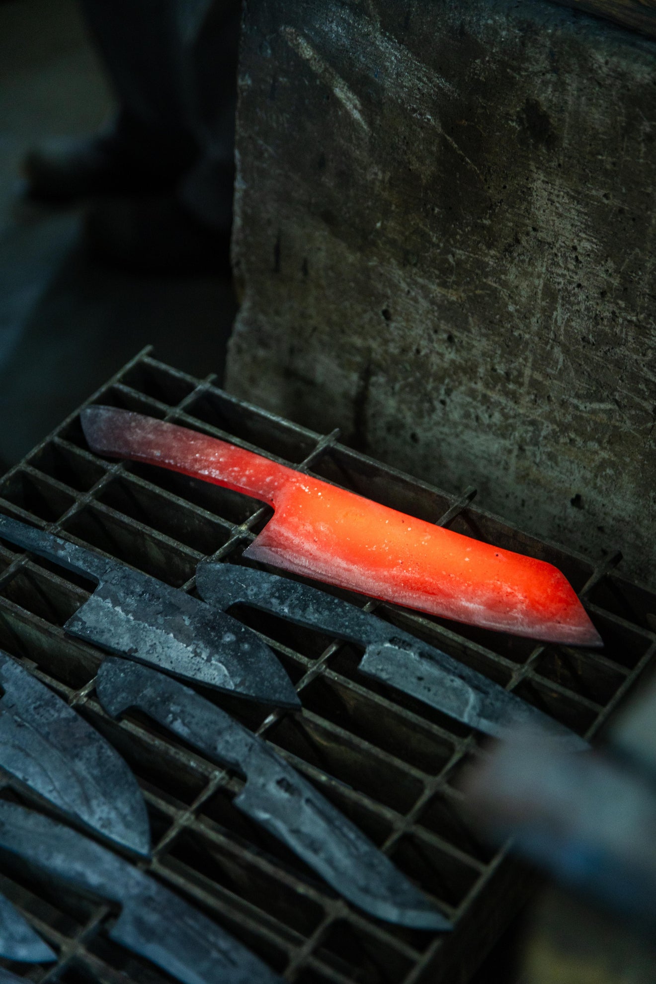 Red hot Tosa Japanese knife blade being heat treated by a blacksmith at Kurotori workshop in Kochi Japan
