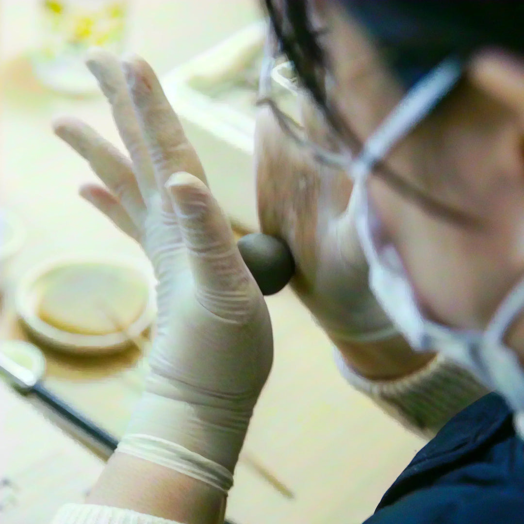 Artisan rolling a ball of clay by hand as part of the traditional forming process in ceramic craft