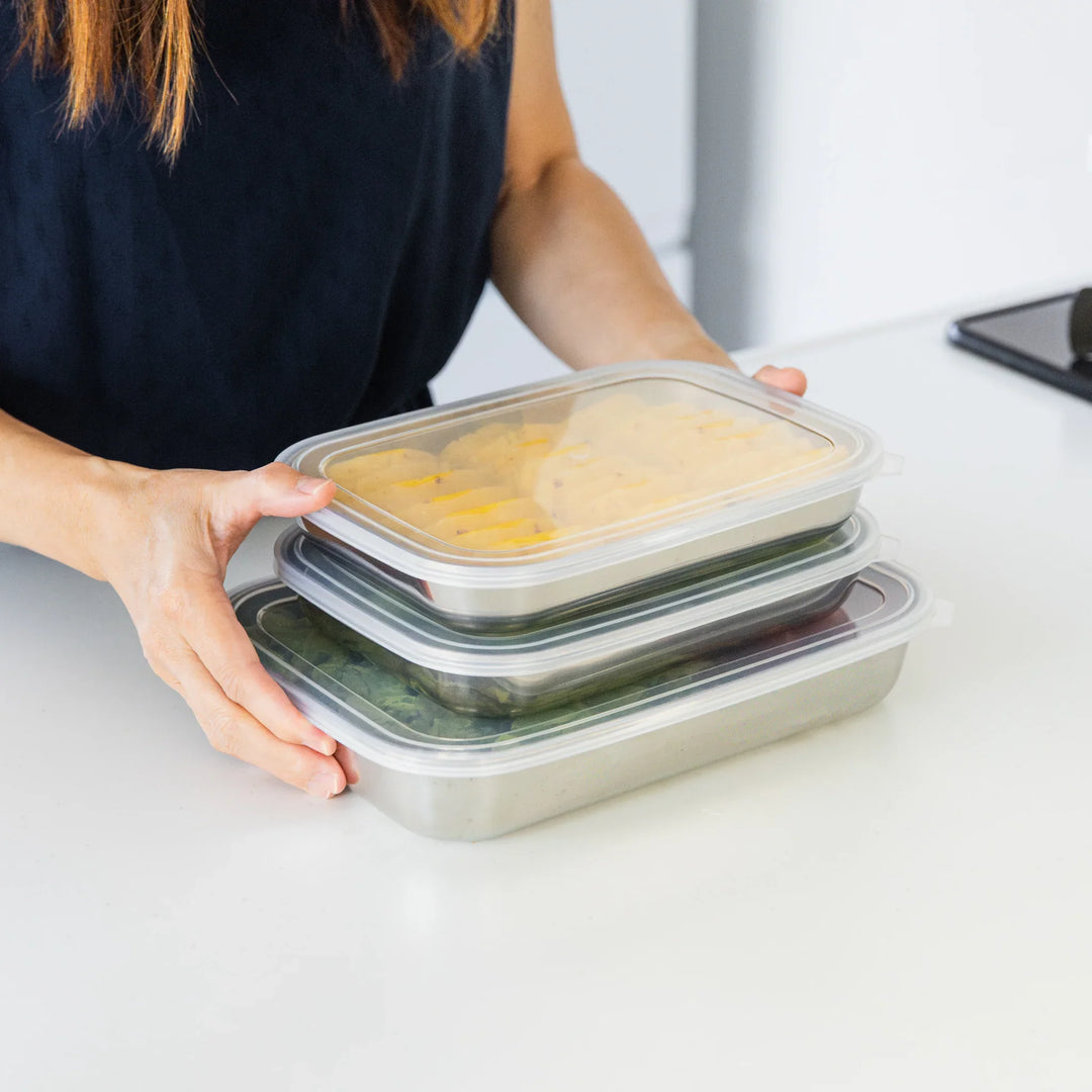 Nami stacking three stainless prep trays with airtight lids, showing how they nest neatly for easy storage.