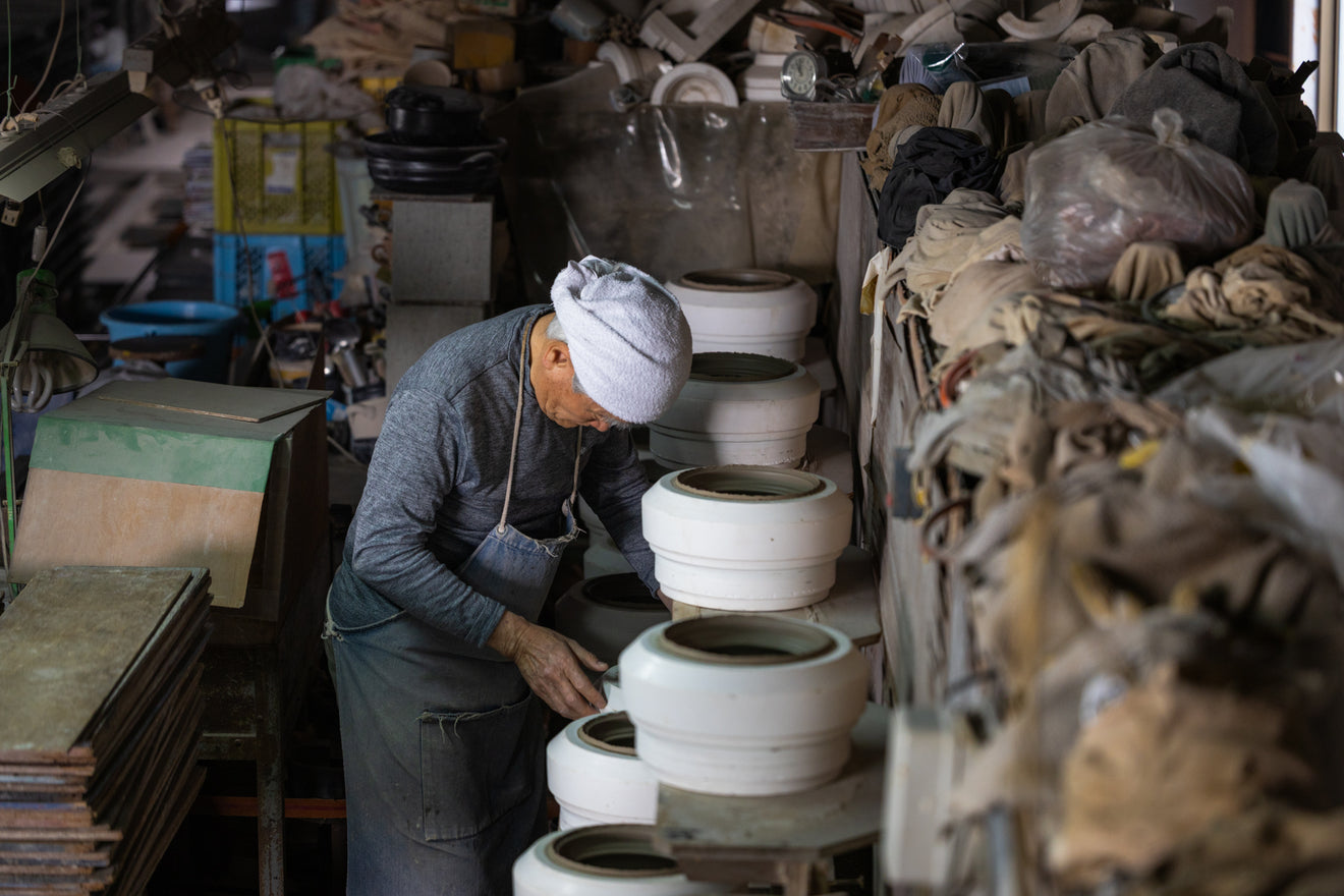 Japanese artisan carefully inspecting molds for ceramic donabe pots at Sento Senga workshop in Mie Japan