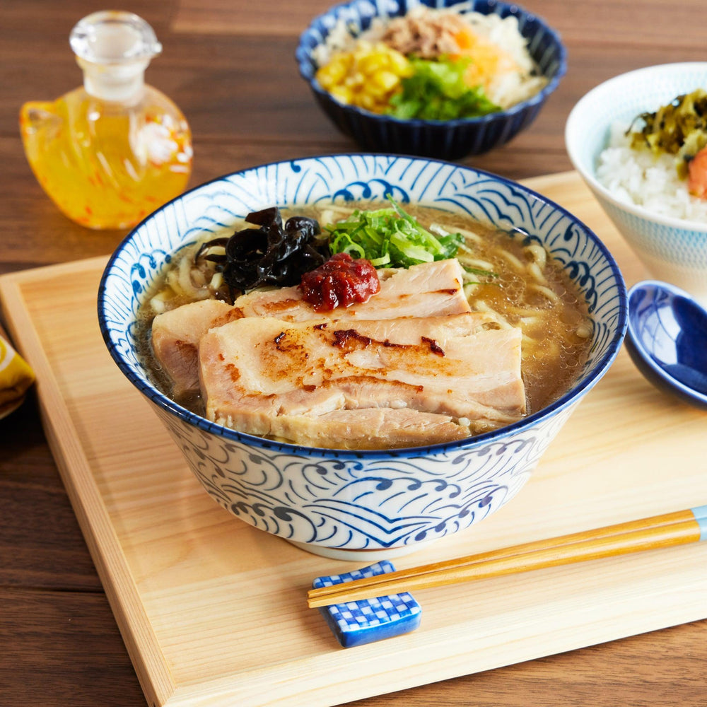 Wave Ripple Ramen Bowl filled with pork ramen, featuring a blue and white swirl pattern and paired with a matching spoon.