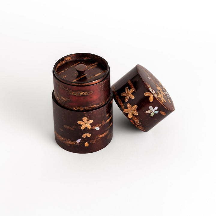 Elegant cherry bark tea caddy with mother-of-pearl cherry blossom inlay, perfect for storing and preserving fine tea leaves.