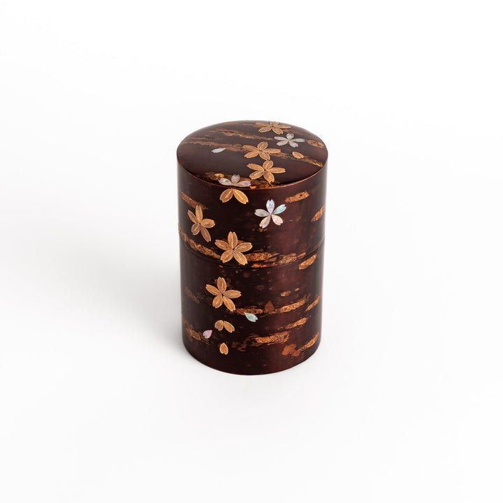 Elegant cherry bark tea caddy with mother-of-pearl cherry blossom inlay, perfect for storing and preserving fine tea leaves.