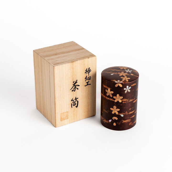Elegant cherry bark tea caddy with mother-of-pearl cherry blossom inlay, presented in a traditional wooden box, perfect for storing and preserving fine tea.