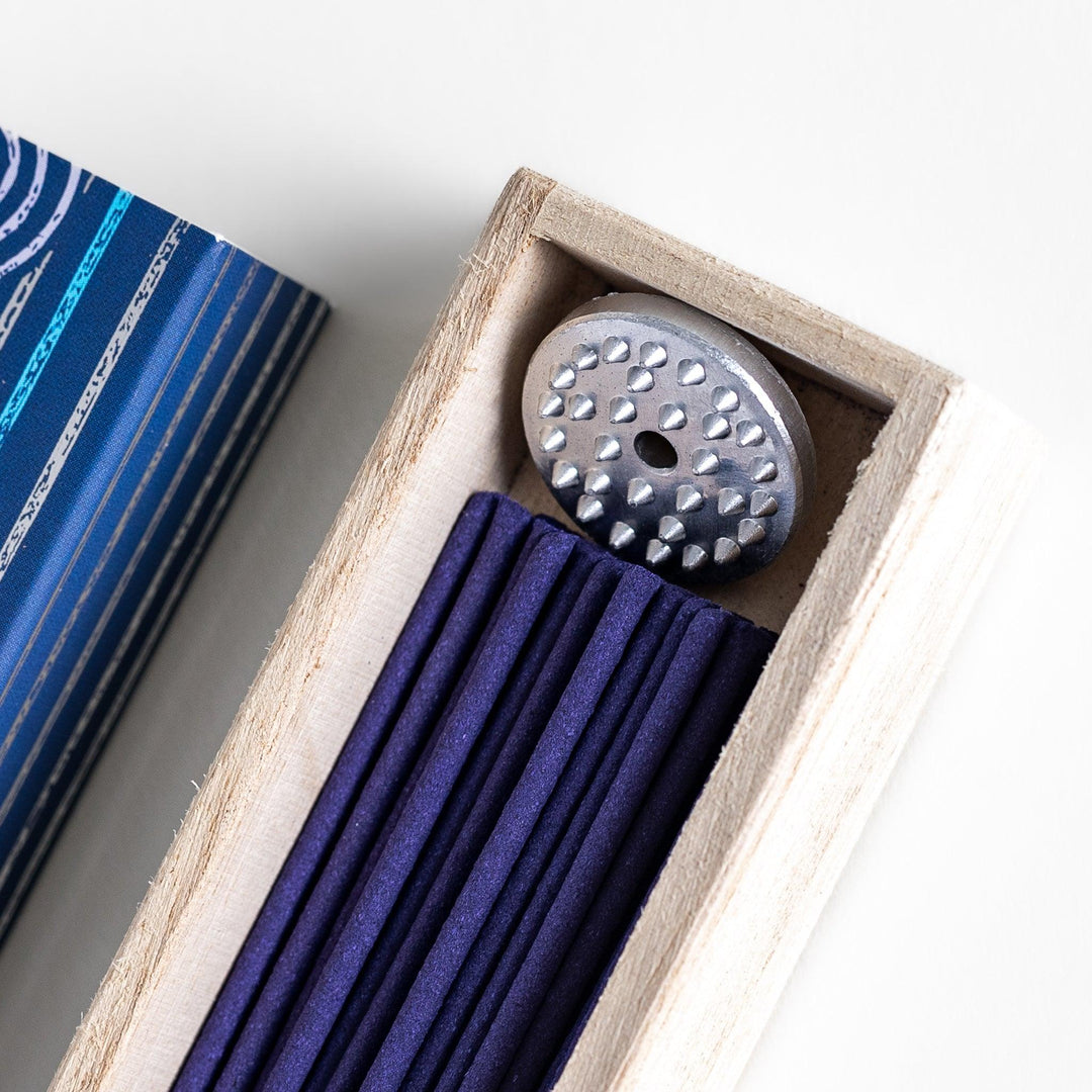 Azure Marine Incense in a light wooden box with deep blue sticks, elegantly packaged in a navy design featuring white circular patterns, evoking a refreshing and invigorating ocean breeze aroma.