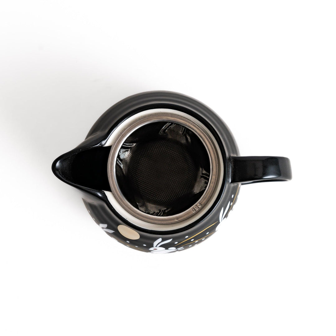 Black teapot featuring white rabbits, golden grasses, and a full moon design, inspired by traditional Japanese autumn motifs.