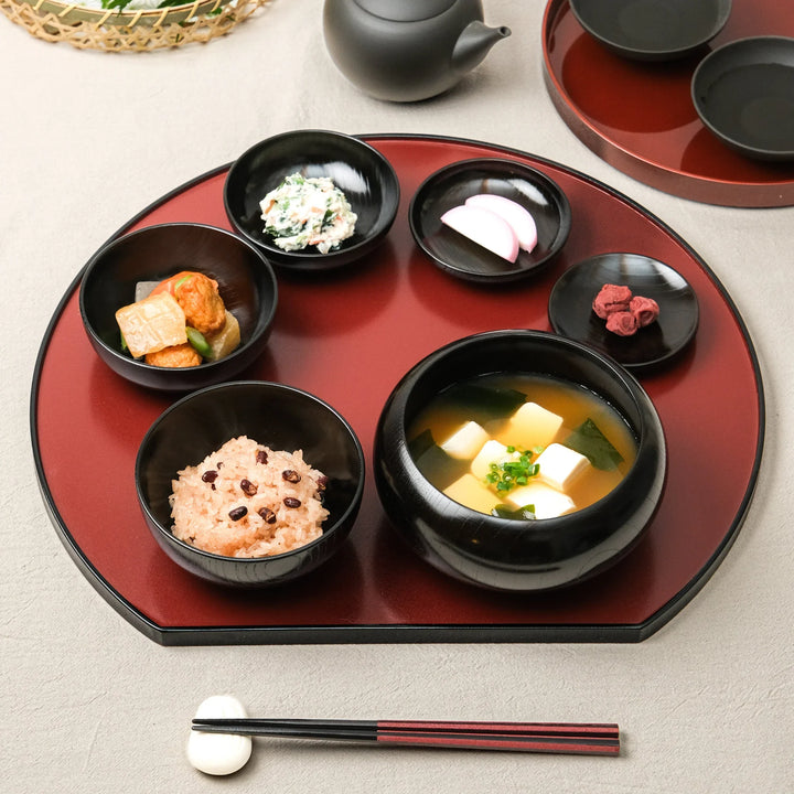 Japanese black lacquered oryoki bowl set with rice, miso soup, and side dishes beautifully arranged on a traditional tray