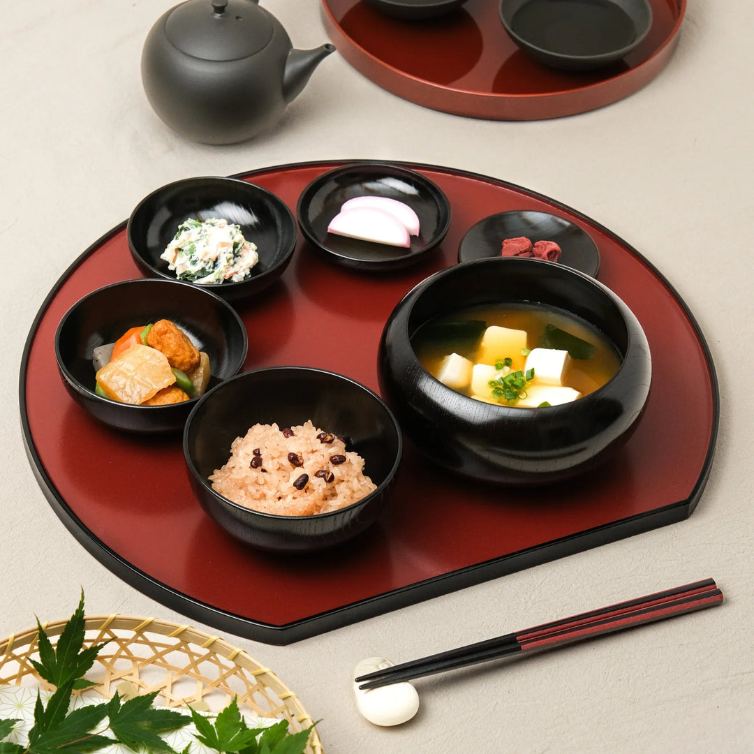 Japanese black lacquered oryoki bowl set with rice, miso soup, and side dishes beautifully arranged on a traditional tray