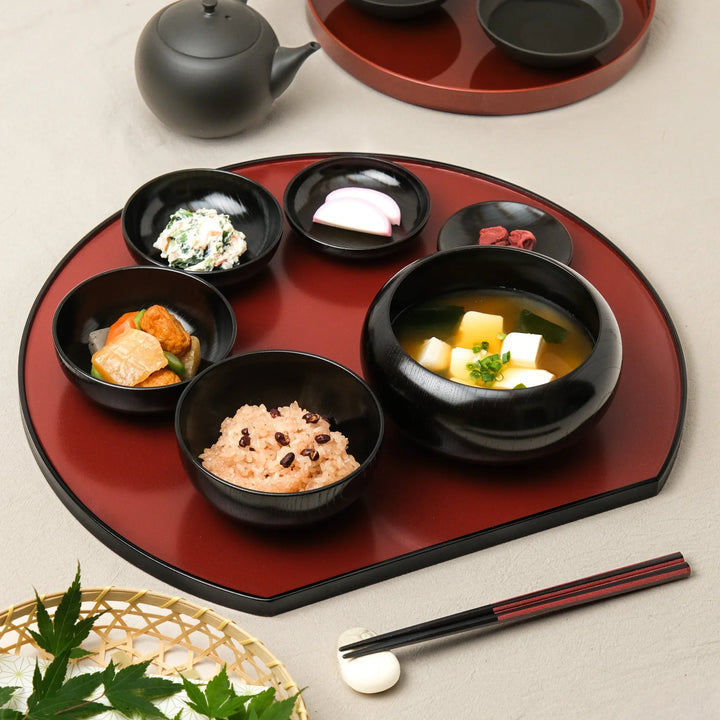 Japanese black lacquered oryoki bowl set with rice, miso soup, and side dishes beautifully arranged on a traditional tray