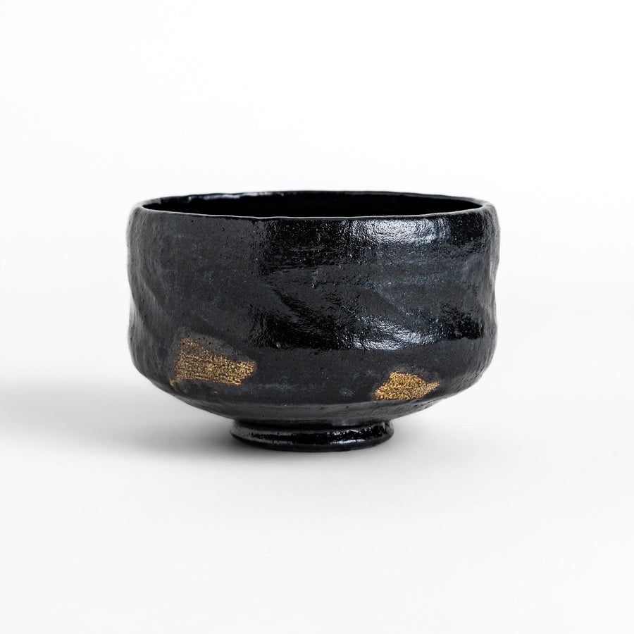 Unique black Raku ware Matcha bowl, handcrafted with traditional Japanese techniques, featuring a rustic texture and a wabi-sabi aesthetic.