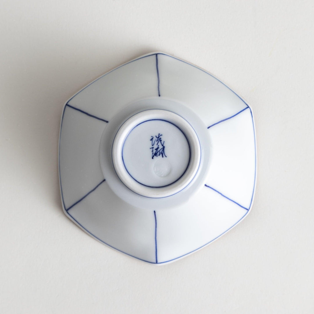 A white ceramic bowl with a flared, scalloped edge and simple blue line detailing.