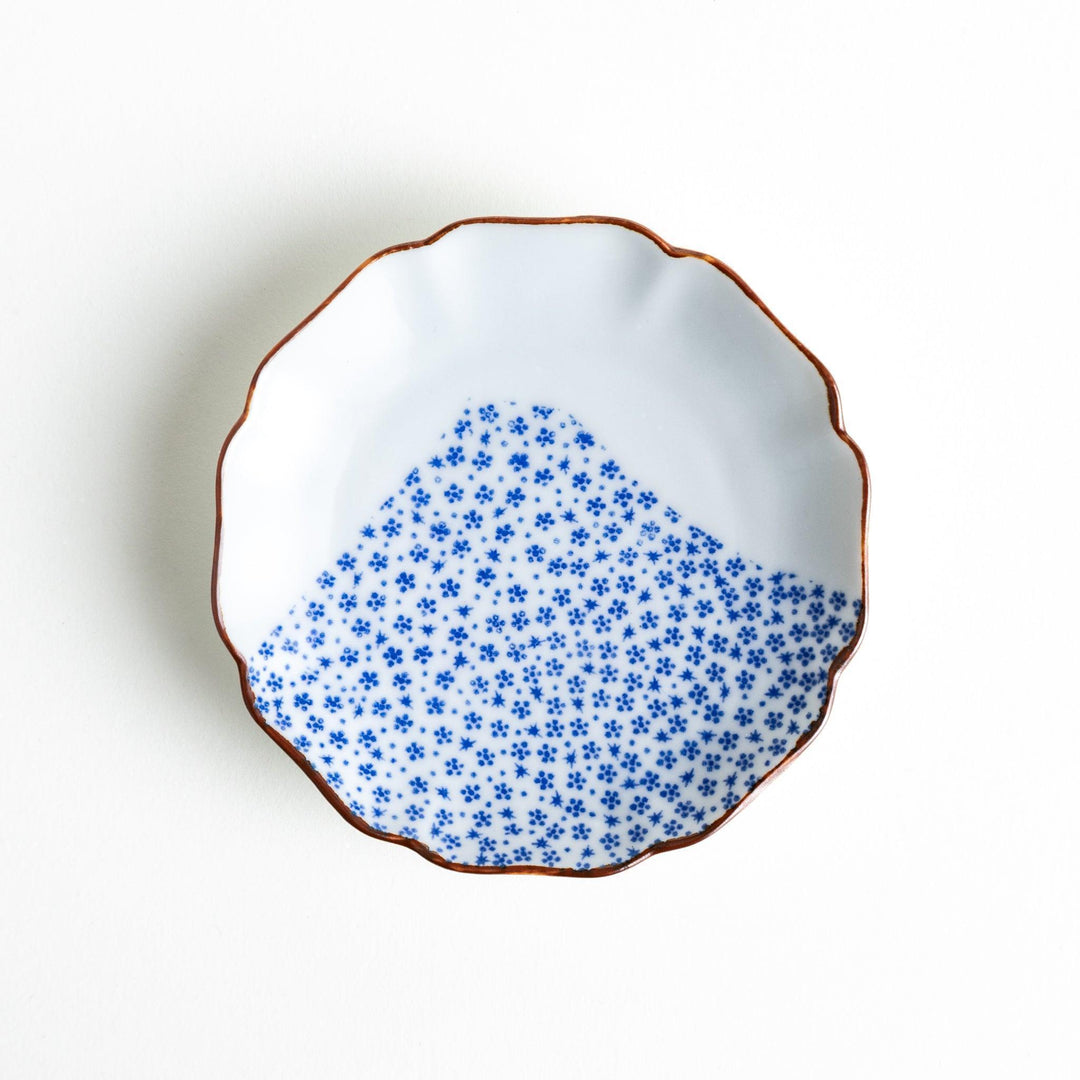 A small dish with a soft blue Mount Fuji pattern filling most of the surface, with a white section creating an abstract mountain-like shape.