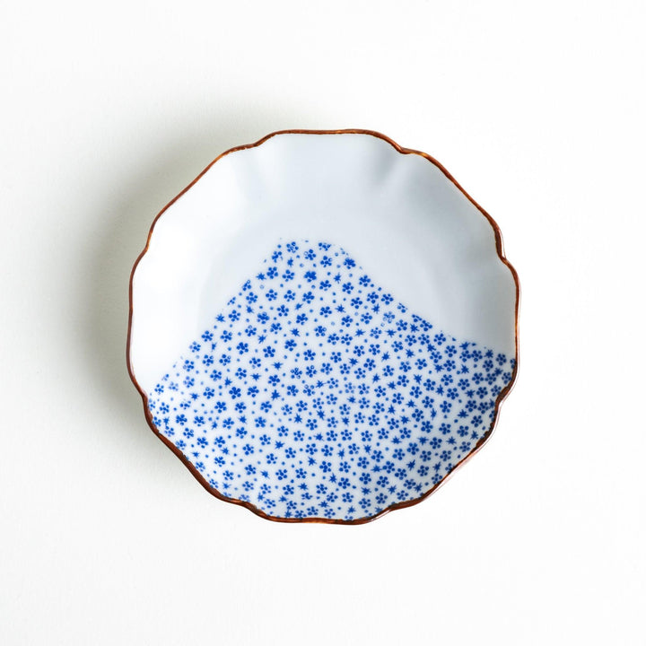 A small dish with a soft blue Mount Fuji pattern filling most of the surface, with a white section creating an abstract mountain-like shape.