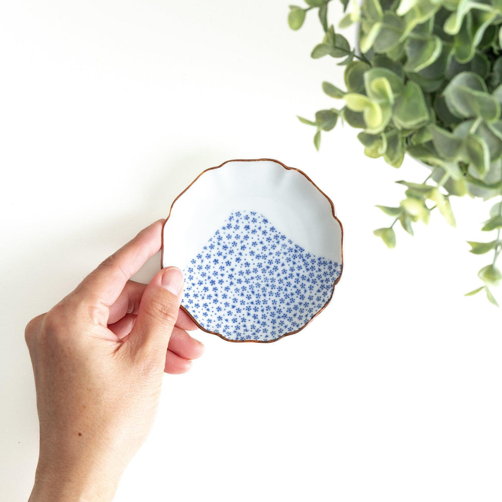 A small dish with a soft blue Mount Fuji pattern filling most of the surface, with a white section creating an abstract mountain-like shape.