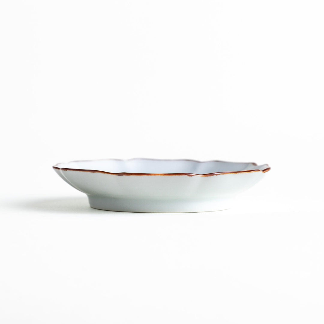 A small dish with a soft blue Mount Fuji pattern filling most of the surface, with a white section creating an abstract mountain-like shape.