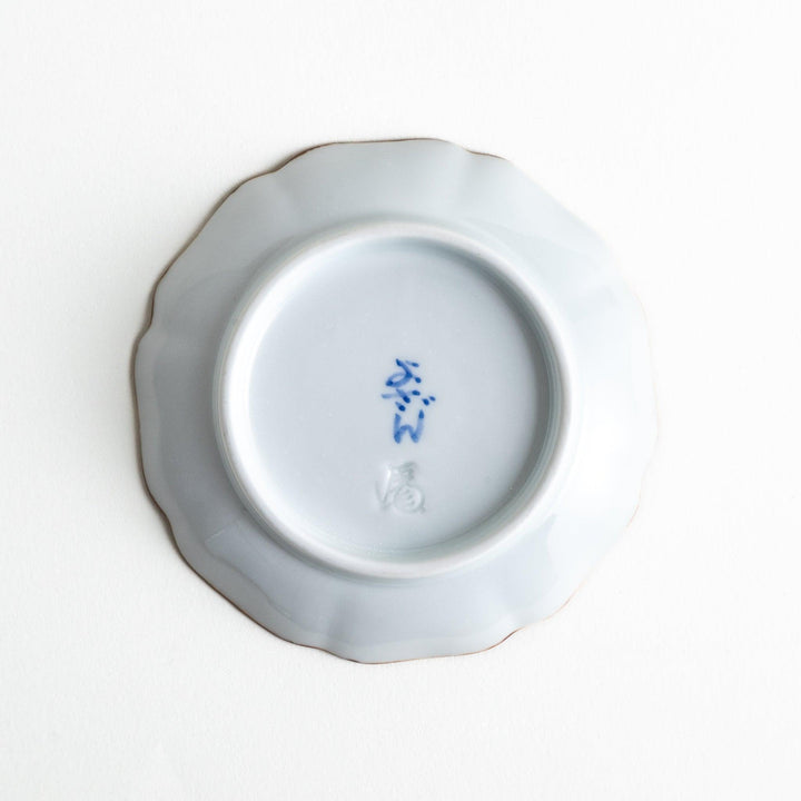 A small dish with a soft blue Mount Fuji pattern filling most of the surface, with a white section creating an abstract mountain-like shape.