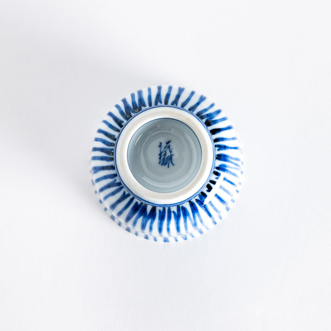 Bottom view of the tea cup showing the small, rounded base and the continuation of the blue stripe design.