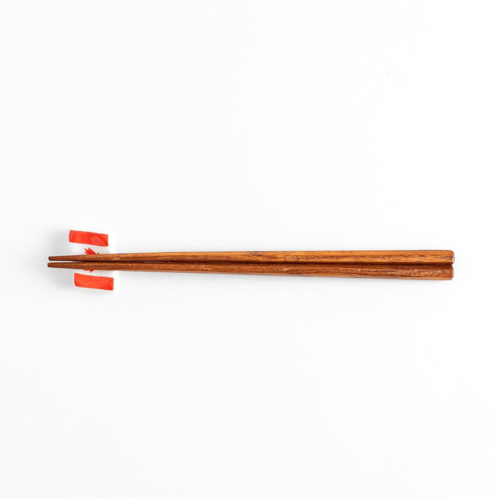 Chopstick rest shaped like the Canadian flag, featuring a red maple leaf in the center, with red borders on each side.