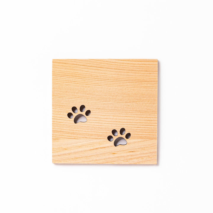 Square hinoki wood mini coaster with two cat paw cutouts, showcasing light grain and protecting surfaces.