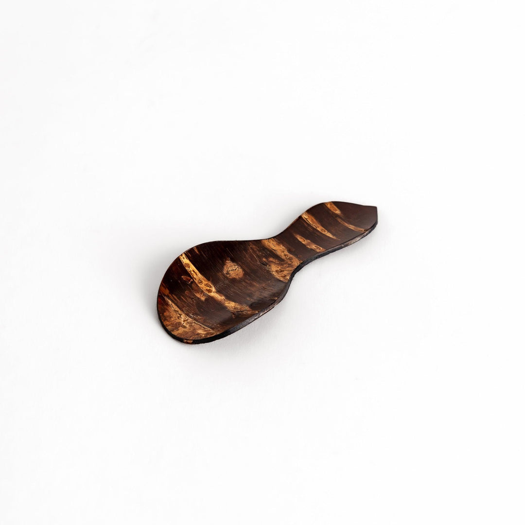 Elegant cherry bark tea scoop with a unique curved design and beautiful wood grain, perfect for measuring loose leaf tea with a touch of natural artistry