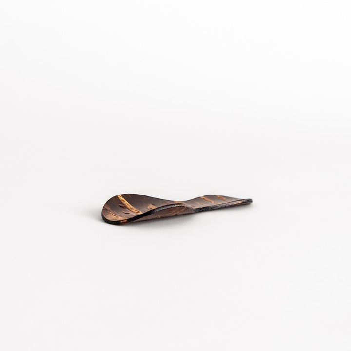 Elegant cherry bark tea scoop with a unique curved design and beautiful wood grain, perfect for measuring loose leaf tea with a touch of natural artistry