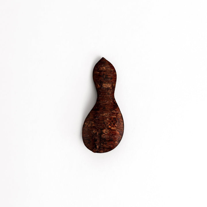 Elegant cherry bark tea scoop with a unique curved design and beautiful wood grain, perfect for measuring loose leaf tea with a touch of natural artistry