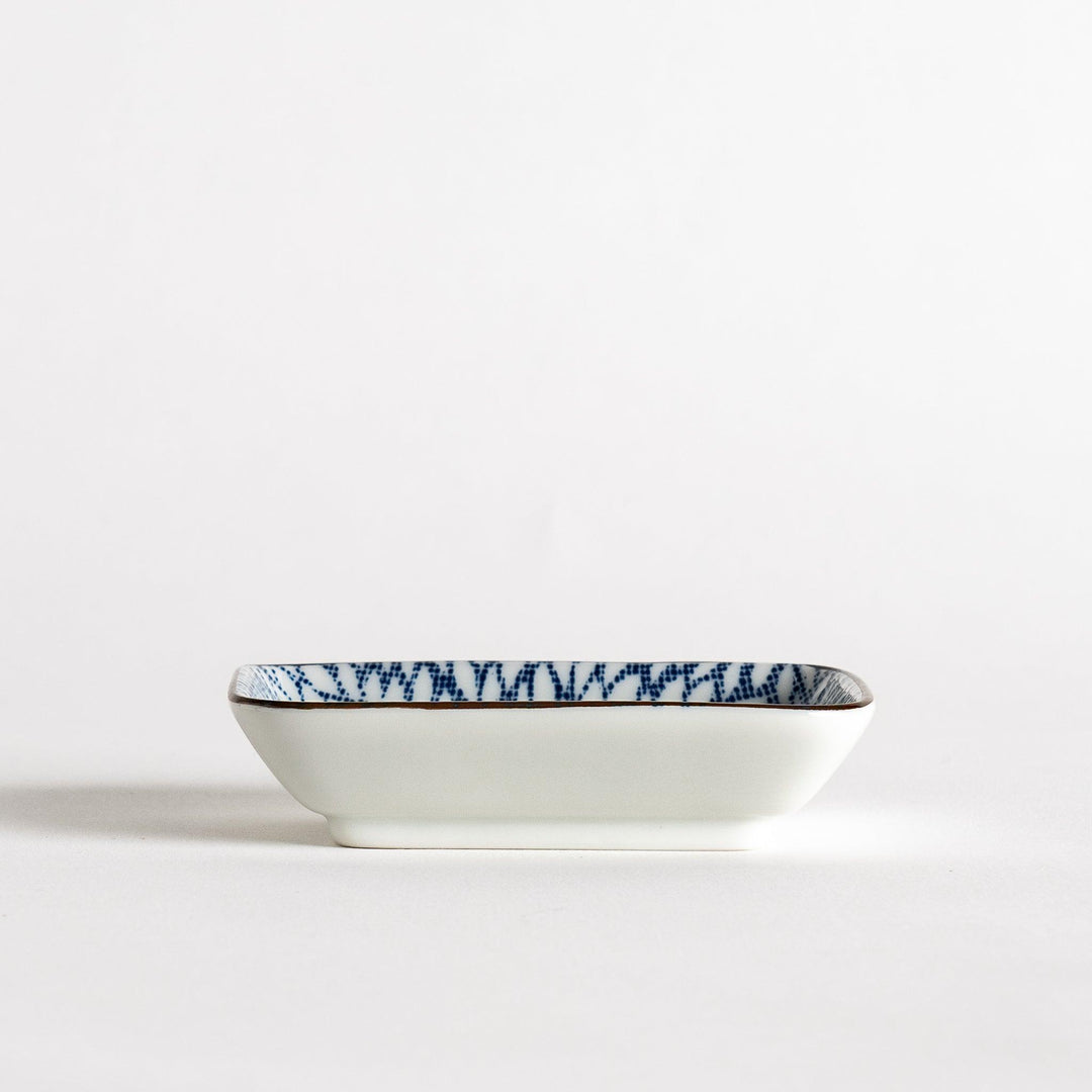 A small rectangular dish featuring a blue herringbone pattern on a white background.